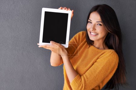 Photo for Technology that fits into my handbag. Portrait of an attractive young woman holding up a digital tablet with a blank screen - Royalty Free Image