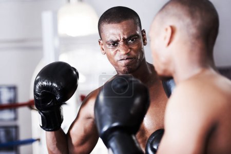 Foto de Estás a punto de caer al suelo. Un boxeador afroamericano a punto de dar un golpe de gracia - Imagen libre de derechos
