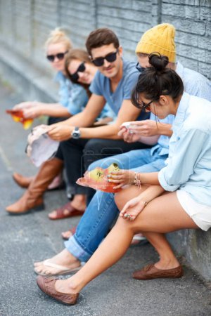 Téléchargez les photos : Rattrapage amis. Jeunes amis hipster assis ensemble à l'extérieur - en image libre de droit