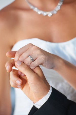 Photo for They share an unbreakable bond. Closeup of a groom leading his bride out of the chapel - Focus on Wedding Ring - Royalty Free Image