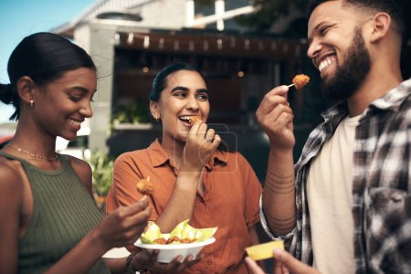 Photo for How yummy are these. a diverse group of friends standing outside a restaurant and bonding while enjoying their takeaway - Royalty Free Image