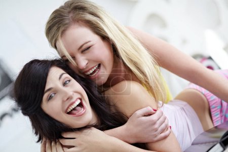 Photo for Portrait, hug and friends in a bedroom having fun, laughing and happy at a sleepover. Face, crazy and women joke, playful and embracing in a bedroom, bonding and smile while joking in their home. - Royalty Free Image