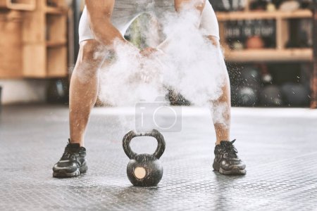 Photo for Dusting before power lifting. Bodybuilder getting ready to lift a heavy kettlebell. Athlete ready to lift weights. Sporty, muscular trainer using powder before a weight lifting routine - Royalty Free Image