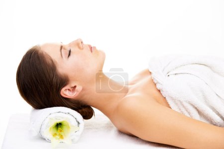 Photo for Treat yourself to a spa day. a young woman getting lying on a massage bed isolated on white - Royalty Free Image
