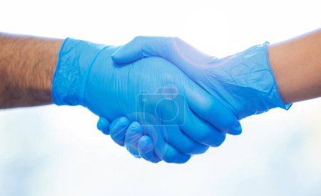 Foto de Un trato es un trato. dos dentistas irreconocibles que usan guantes y se dan la mano - Imagen libre de derechos