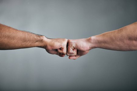 Photo for Go out and get it. two unrecognizable male athletes fist bumping against a grey background - Royalty Free Image