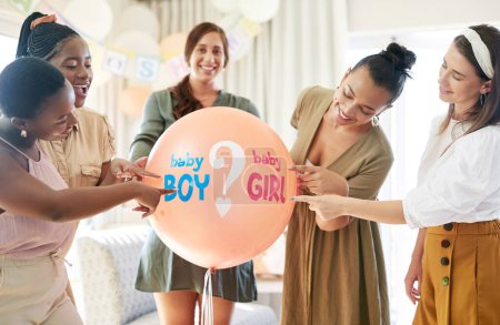 Photo for We wonder what the gender would be. a group of women about to pop a balloon for a gender reveal during a baby shower - Royalty Free Image
