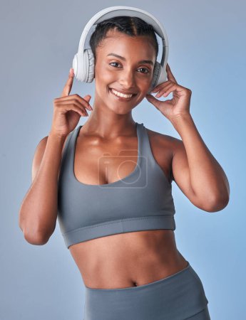 Photo for Youre one dance away from a healthier day. Studio shot of a fit young woman using headphones against a grey background - Royalty Free Image