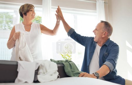 Photo for We packed and folded that like champs. a mature couple high fiving while folding their laundry - Royalty Free Image