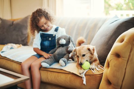 Photo for Enjoying home time with my dog. an adorable young girl sitting on the sofa at home and bonding with her dog - Royalty Free Image