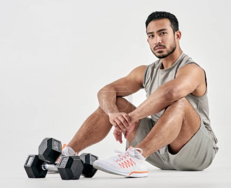 Photo for If youre persistent youll get it - if youre consistent youll keep it. Studio portrait of a muscular young man posing with dumbbells against a white background - Royalty Free Image