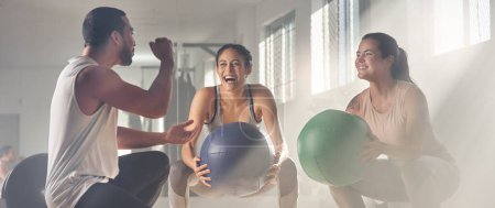 Photo for Get some assistance, itll be fun. two women using fitness balls while working out with their trainer - Royalty Free Image
