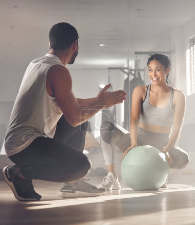 Photo for Keep going until you make yourself proud. a woman using a exercise ball while working out with a personal trainer - Royalty Free Image