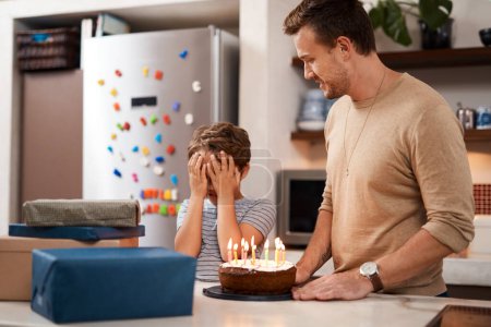 Foto de Adelante, abre los ojos ahora. un hombre sorprendiendo a su hijo con pastel y regalos en su cumpleaños - Imagen libre de derechos