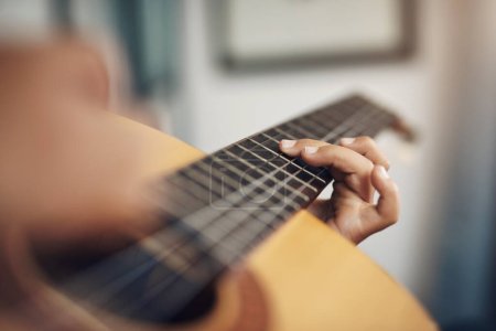Foto de Tocar un instrumento es un ejercicio excelente para tu mente. un chico irreconocible tocando la guitarra en casa - Imagen libre de derechos