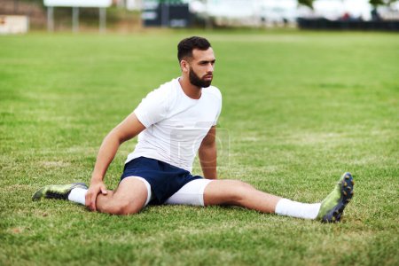Photo for A good game starts with a good stretch. a young man doing stretches on a rugby field - Royalty Free Image