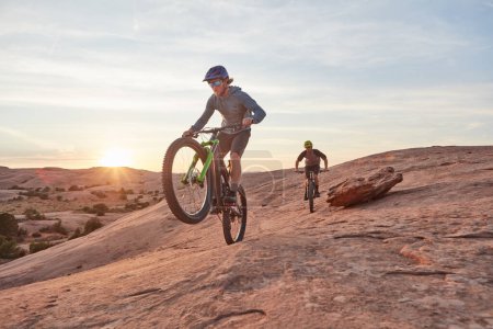 Foto de A toda velocidad. tiro de longitud completa de dos jóvenes atletas masculinos ciclismo de montaña en el desierto - Imagen libre de derechos
