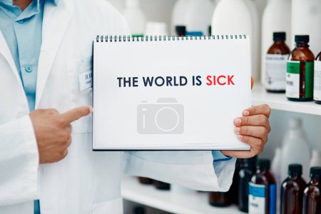 Photo for Our planet is on sick leave until further notice. a scientist holding a sign with The world is sick on it in a laboratory - Royalty Free Image