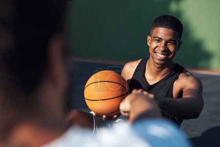 Foto de Gracias por el gran juego. un joven deportivo dando a su compañero de equipo un puñetazo en una cancha de baloncesto - Imagen libre de derechos