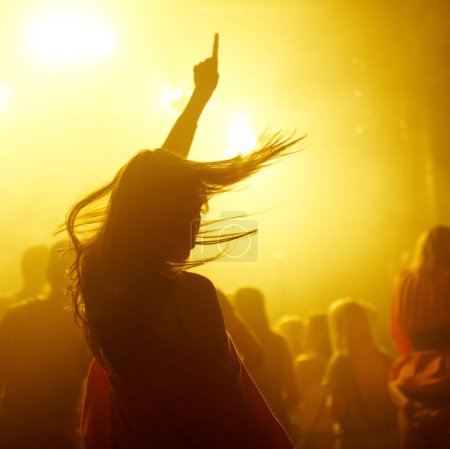 Téléchargez les photos : Danse, rave et femme lors d'un concert, d'un événement disco ou d'un festival de transe psychédélique. Soirée, énergie et femme dansant ou se déplaçant vers une chanson avec une lumière jaune à la boîte de nuit techno ou fête avec DJ - en image libre de droit