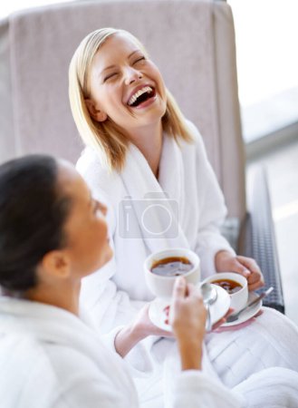 Téléchargez les photos : Rire, parler et amis boire du thé au spa avant le luxe, la beauté et l'autosoin. Joyeux, drôle et les femmes coller, dans la conversation et profiter de boissons chaudes ensemble au salon de bien-être - en image libre de droit