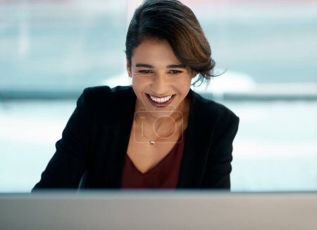 Foto de Mantenerse positivo. una atractiva joven empresaria sentada sola y trabajando en su ordenador en la oficina - Imagen libre de derechos