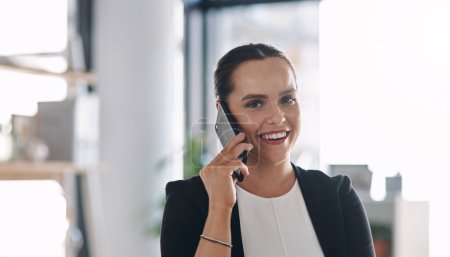 Photo for Hearing good news always puts a smile on my face. Portrait of an attractive young businesswoman answering a phone call inside her office - Royalty Free Image