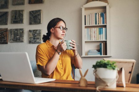 Photo for Grab your coffee and get it done. a young woman having coffee and looking thoughtful while working from home - Royalty Free Image
