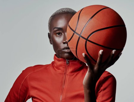 Photo for Call me the queen of the basketball court. Studio shot of an attractive young woman playing basketball against a grey background - Royalty Free Image