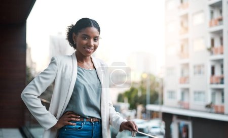 Foto de Mis compañeros a punto de apoderarse de la ciudad. Retrato de una joven empresaria confiada parada afuera en el balcón de una oficina moderna - Imagen libre de derechos