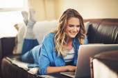 My blog is almost done. a relaxed young woman using a laptop on the sofa at home Poster #654576940