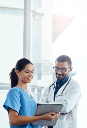 Foto de Los doctores inteligentes usan tecnología inteligente. dos médicos jóvenes usando una tableta digital en un hospital moderno - Imagen libre de derechos