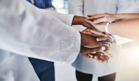 Téléchargez les photos : Votre santé entre leurs mains. un groupe de médecins unissant leurs mains en solidarité dans un hôpital - en image libre de droit