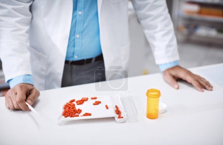 Foto de Asegurarse de que no haya posibilidad de sobredosis. un farmacéutico contando medicamentos en una farmacia - Imagen libre de derechos