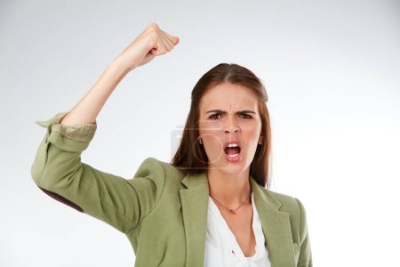 Photo for I demand more. Studio portrait of a young woman shaking her fist in anger against a grey background - Royalty Free Image