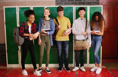 Photo for Study buddies for life. Portrait of a group of cheerful young school kids talking to each other before class inside of a school during the day - Royalty Free Image