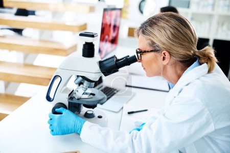 Photo for Scientists help us understand how the world works in specific ways. a mature scientist using a microscope in a lab - Royalty Free Image