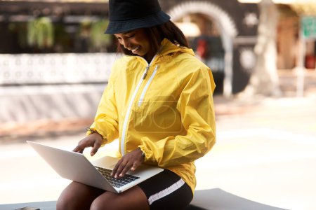 Photo for Dare to stand out and be yourself to the fullest. an attractive young woman using a laptop while relaxing outdoors in the city - Royalty Free Image