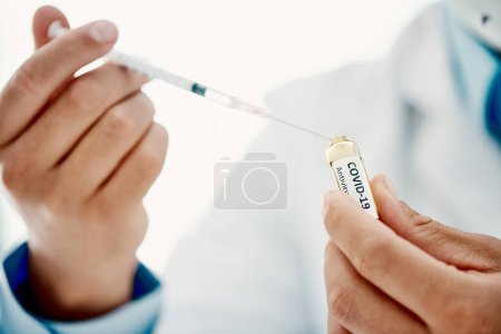 Foto de Te tengo cubierto contra Covid. un científico que extrae medicamentos usando una jeringa de una ampolla con 2019-nCov - Imagen libre de derechos