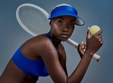 Foto de Juego al tenis y lo hago bien. Estudio de una joven deportista posando con equipo de tenis sobre un fondo gris - Imagen libre de derechos