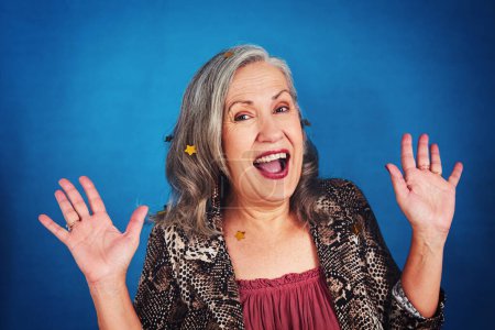 Foto de Estoy tan emocionada. Retrato de una mujer mayor funky y elegante posando en el estudio sobre un fondo azul - Imagen libre de derechos