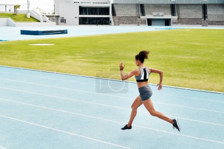 Photo for Running is a passion. Full length shot of an attractive young athlete running a track field alone during a workout session outdoors - Royalty Free Image