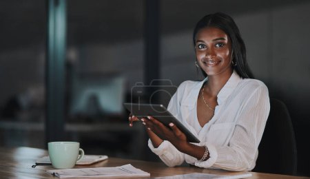 Photo for Now you can make smart moves like everyone else. Portrait of a young businesswoman using a digital tablet in an office at night - Royalty Free Image