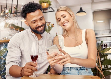 Foto de Es bueno para un poco de acoso social. una pareja joven usando un smartphone juntos en un restaurante - Imagen libre de derechos