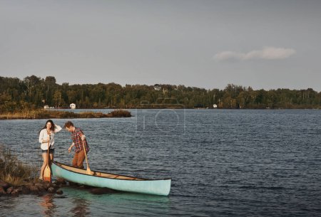Téléchargez les photos : Les amoureux de la nature dans leur élément. un jeune couple faisant une balade en canot sur le lac - en image libre de droit