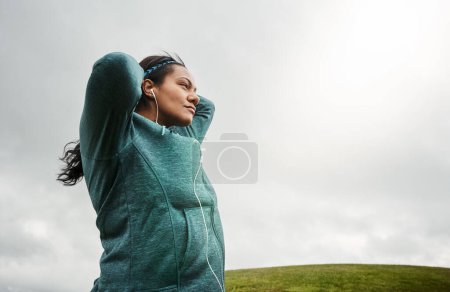 Photo for Pre workout mental prep. an attractive young woman stretching while out for a run in nature - Royalty Free Image