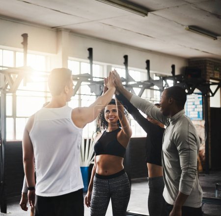 Photo for Teamwork makes the fitness dream work. a group of young people giving each other a high five during their workout in a gym - Royalty Free Image