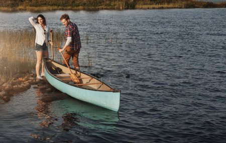 Téléchargez les photos : Faire ce que font les amoureux de la nature. un jeune couple faisant une balade en canot sur le lac - en image libre de droit