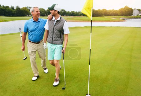 Foto de Deberíamos hacer esto de nuevo. un hombre mayor y su hijo adulto jugando al golf - Imagen libre de derechos
