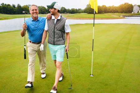 Téléchargez les photos : Le bonheur est une longue marche avec un putter. deux amis jouant au golf ensemble dans leur temps libre - en image libre de droit